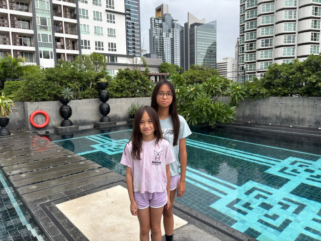 Rooftop swimming pool at Mövenpick Hotel Sukhumvit 15 Bangkok with shaded loungers and city skyline views.