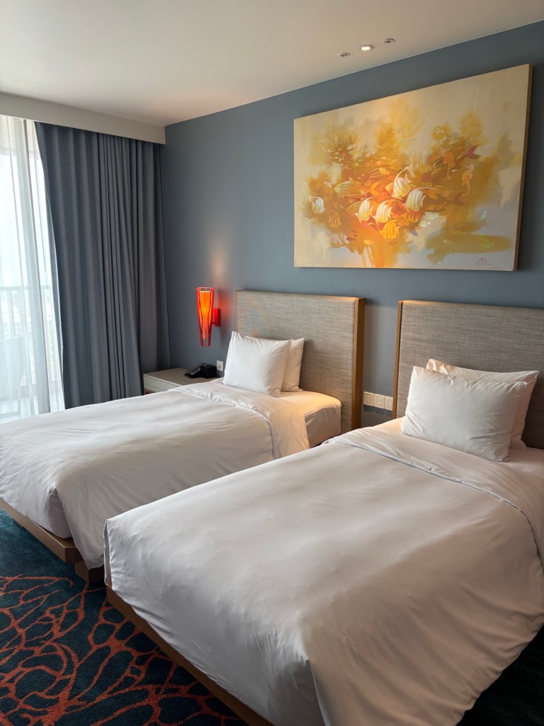 Twin beds in a modern guest room at Holiday Inn Resort Vana Nava Hua Hin, featuring soft neutral tones, plush bedding, and a welcoming atmosphere.