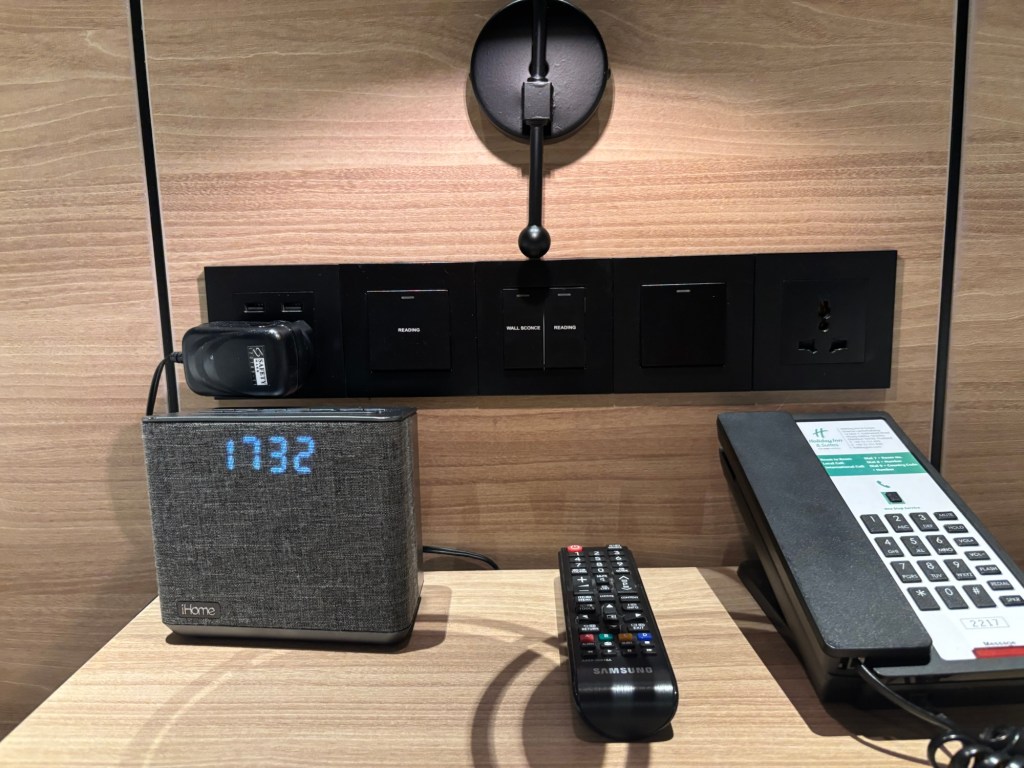 Universal multi‑region plug socket in a guest room at Holiday Inn & Suites Siracha Laemchabang, suitable for UK, EU, US, and Asian plugs.