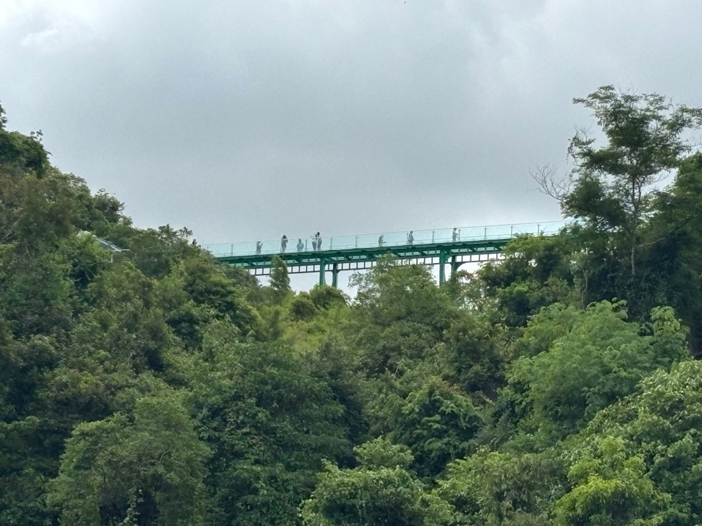 Distant view of the glass Skywalk at Wat Khao Tabaek in Chonburi, Thailand, perched on a hill with panoramic countryside views