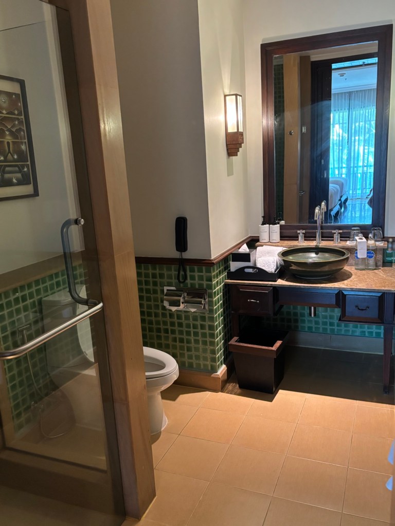 Contemporary hotel bathroom with a white ceramic toilet, marble countertop, and decorative wall mirror at InterContinental Pattaya Resort in Thailand.