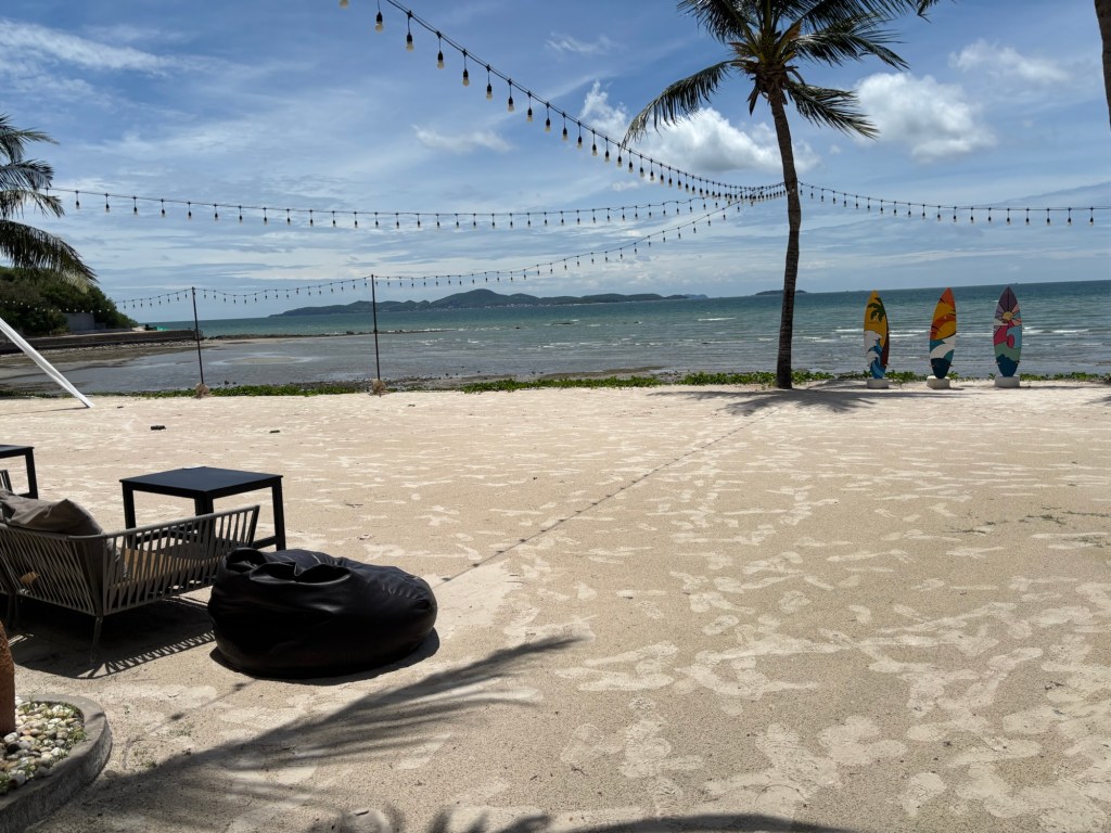 Scenic view of the private sandy beach with gentle waves and tropical greenery at InterContinental Pattaya Resort in Thailand.